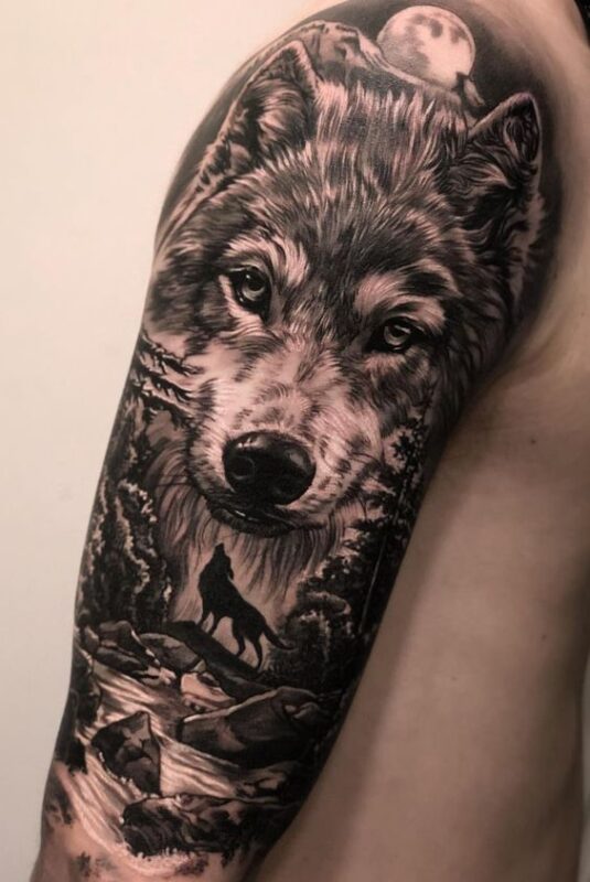 tatuaje de lobo con paisaje en hombro