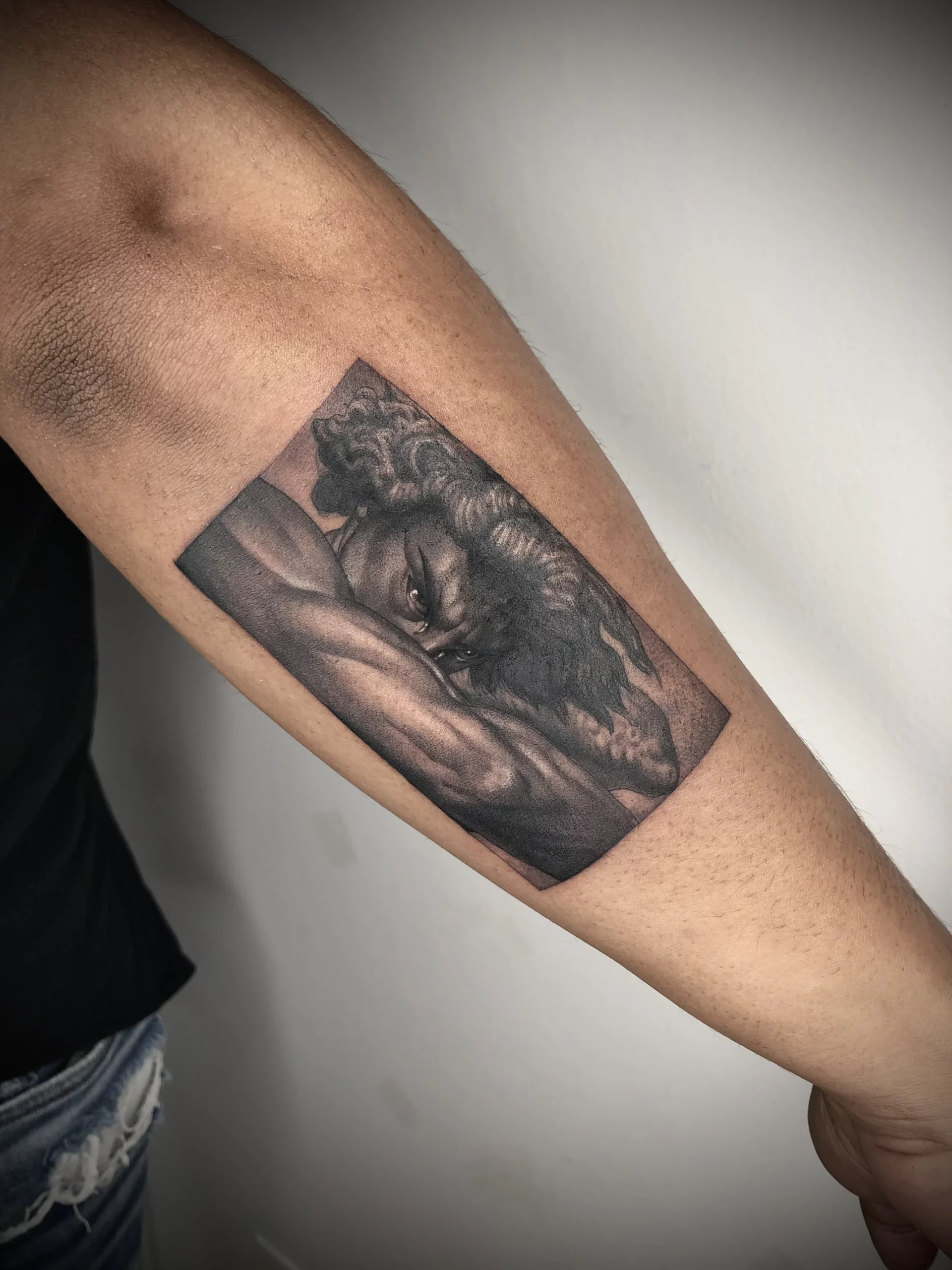 tatuaje angel caido realismo en brazo