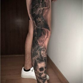 tatuaje realista de cuervos tatuados en pierna con craneo