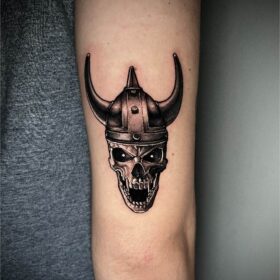 tatuaje craneo vikingo en brazo en sombras