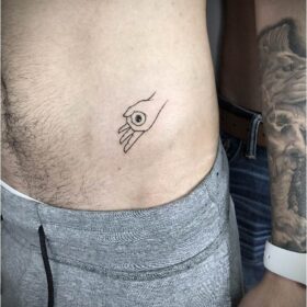 tatuaje pequeño de mano con ojo en cadera para hombre
