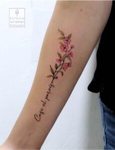 tatuaje letras y flores pequeñas en antebrazo